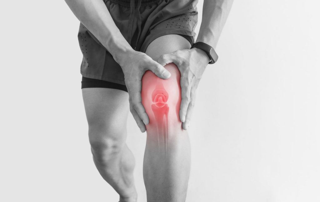 Person experiencing arthritis pain, holding their knee.