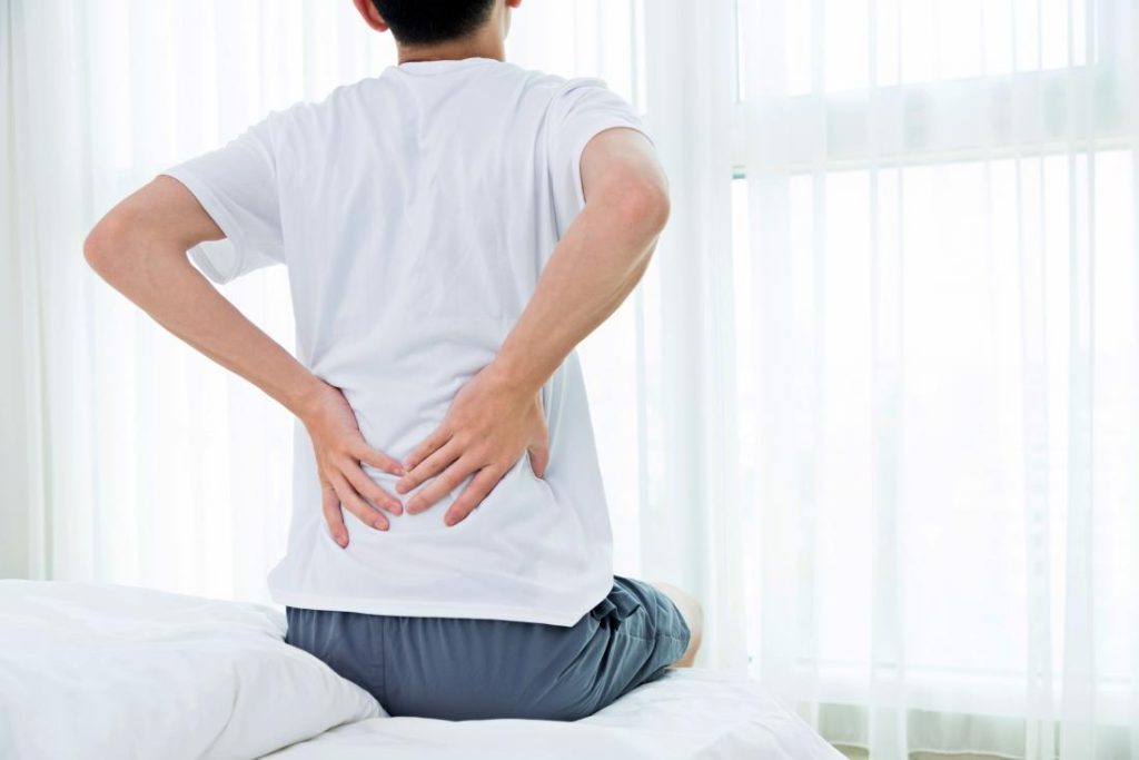 Person experiencing hip pain, holding their hip.